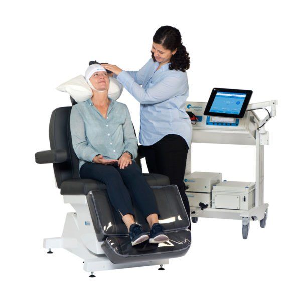 A woman is putting a bandage on a patient 's head