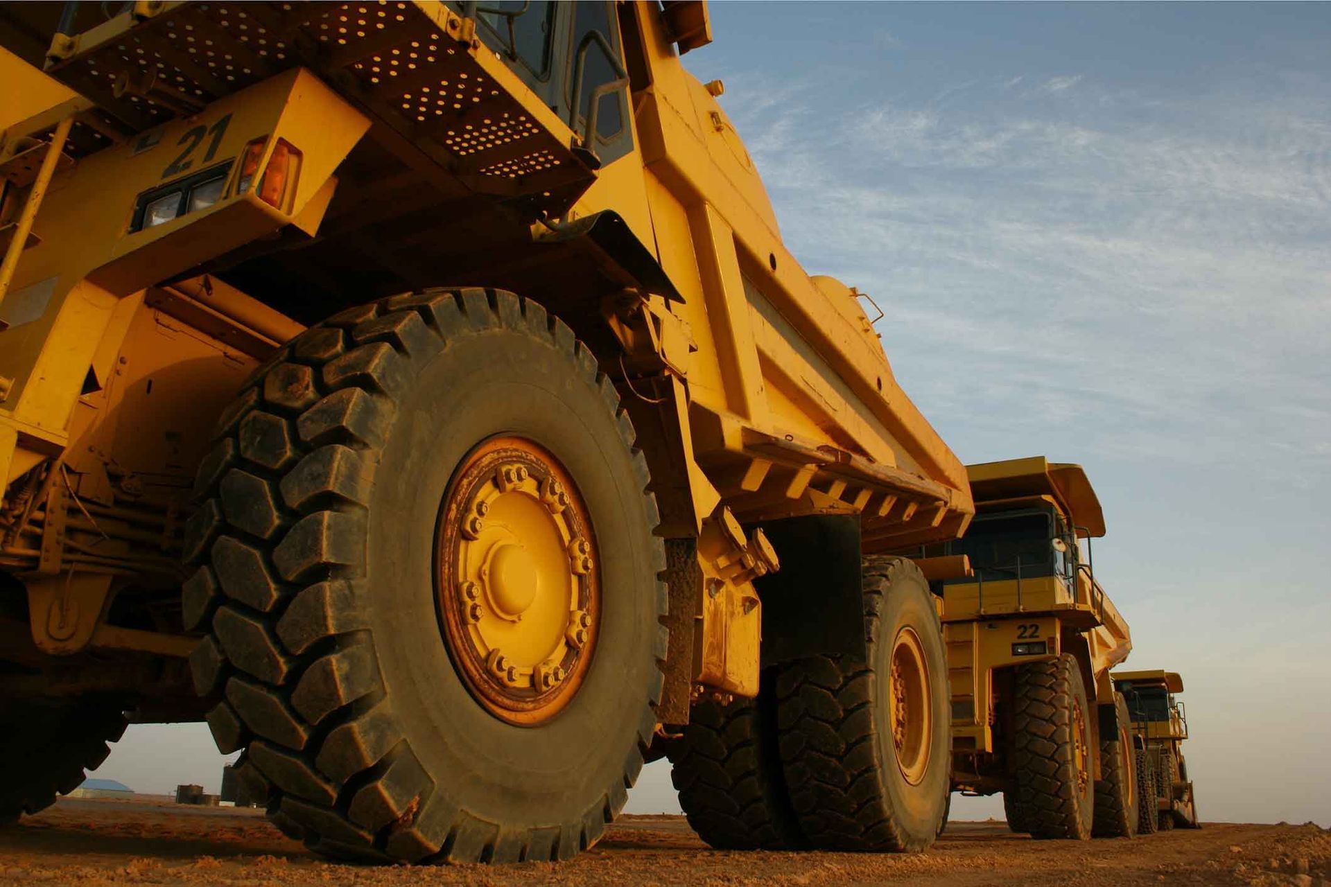 A Row Of Yellow Dump Trucks Are Parked In A Dirt Field – Delacombe, VIC  - Transport Tyres
