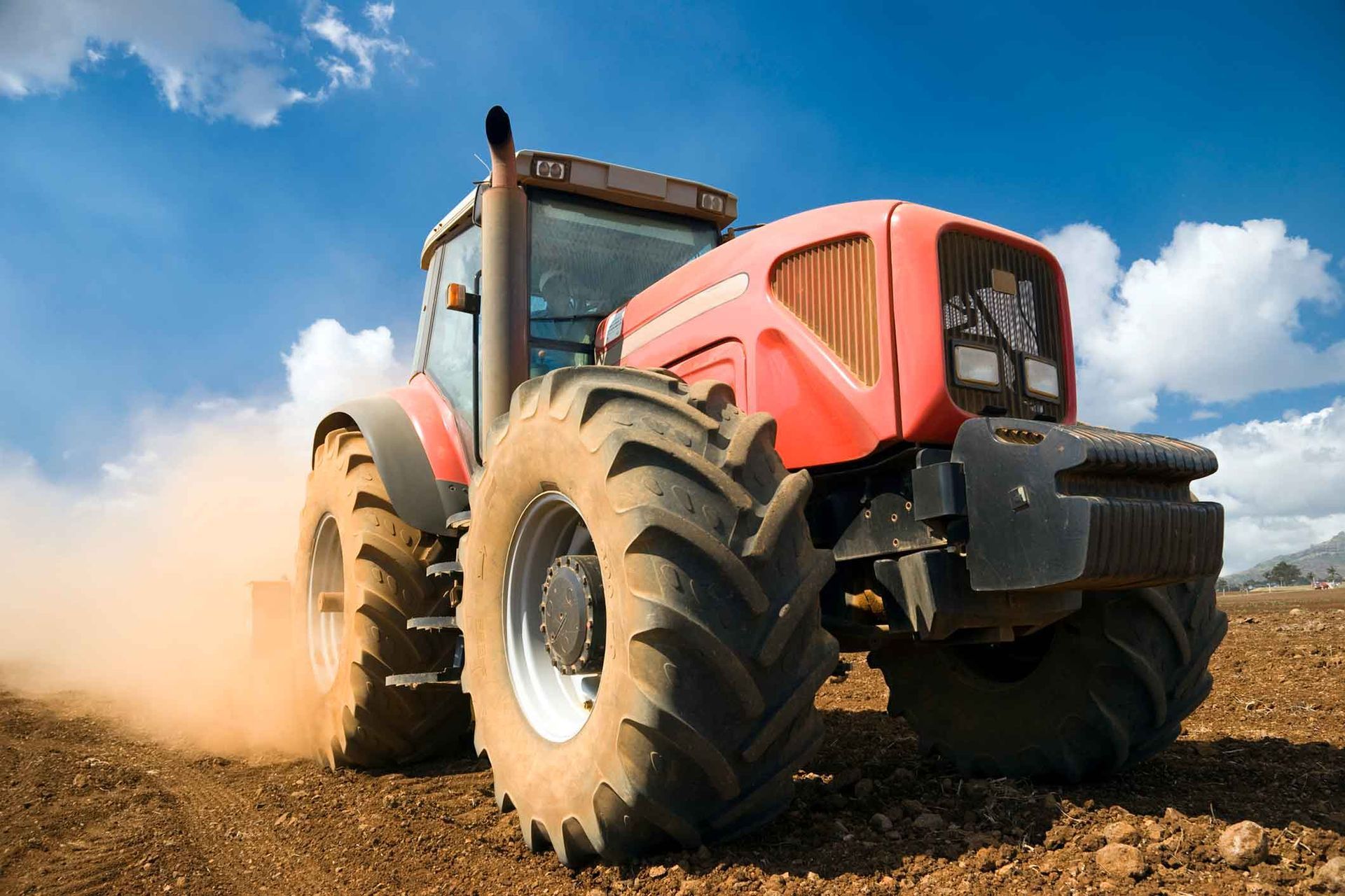 A Red Tractor Is Driving Through A Dirt Field – Delacombe, VIC  - Transport Tyres