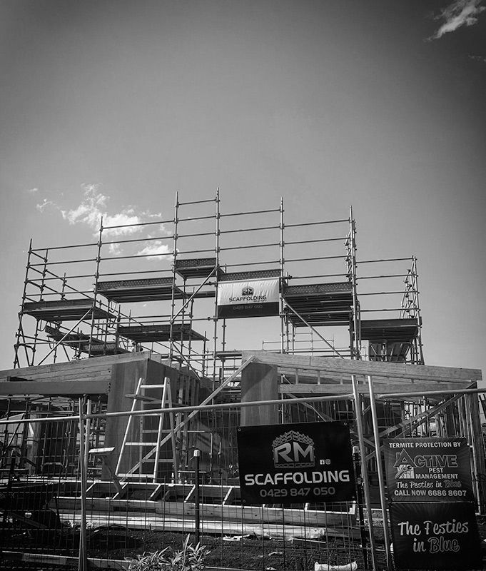 A Construction Site With Scaffolding and a Sign That Says RM Scaffolding — RM Scaffolding Solutions in Tweed Coast, NSW
