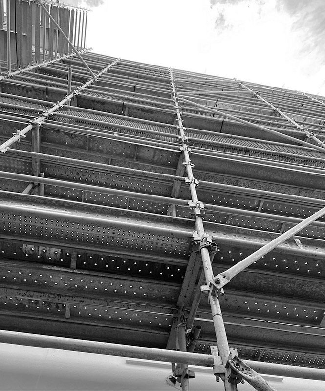 A Black and White Photo of a Building Under Construction With Scaffolding — RM Scaffolding Solutions in Byron Bay, NSW