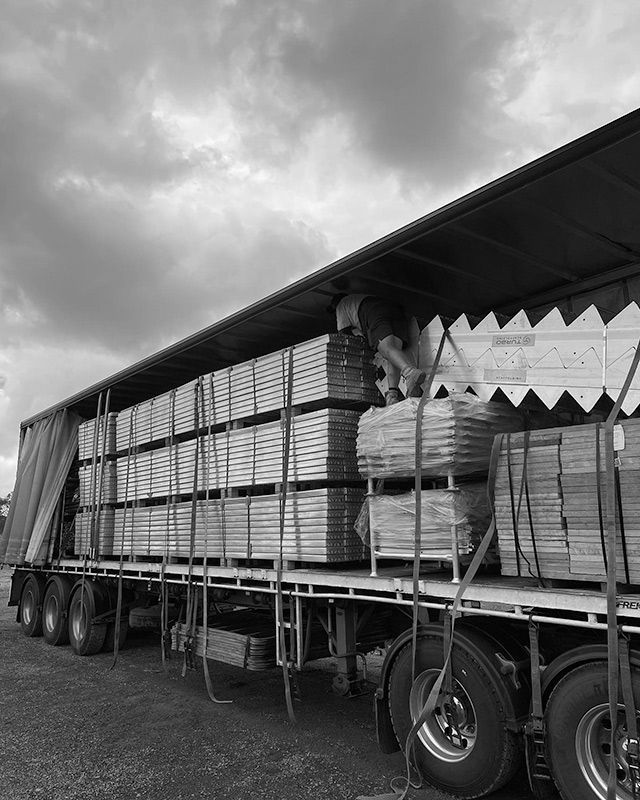 A Black and White Photo of a Truck Filled With Wooden Pallets — RM Scaffolding Solutions in Yamba, NSW