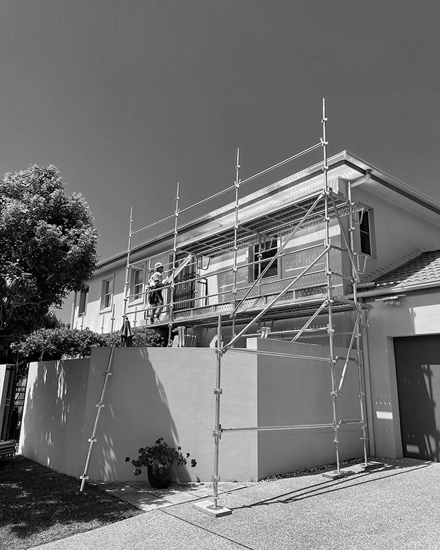 A Black and White Photo of a House With Scaffolding Around It — RM Scaffolding Solutions in Tweed Coast, NSW