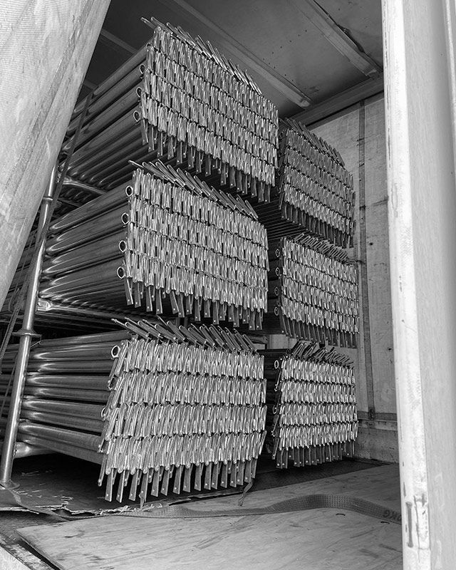 A Black and White Photo of a Stack of Metal Pipes — RM Scaffolding Solutions in Lennox Head, NSW