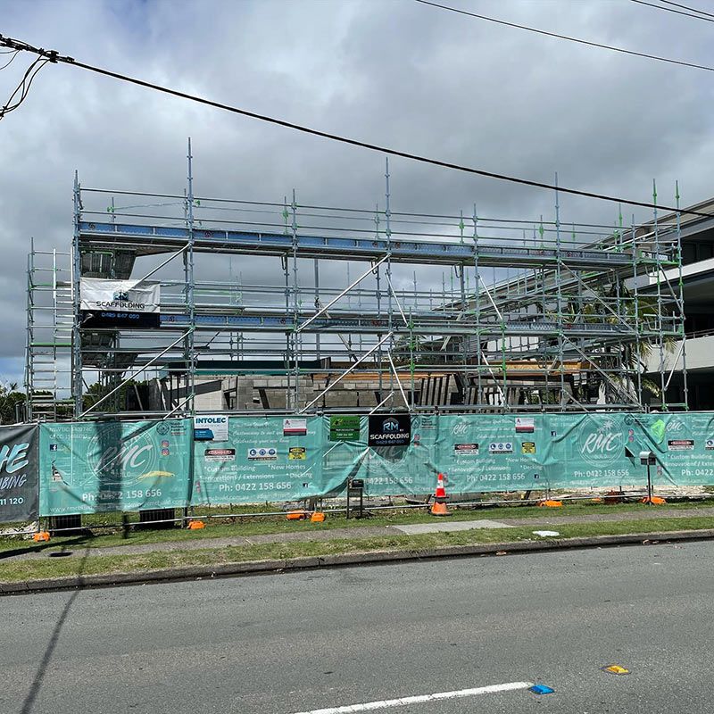 A Building Under Construction With Scaffolding and a Fence Around It — RM Scaffolding Solutions in Northern Rivers, NSW