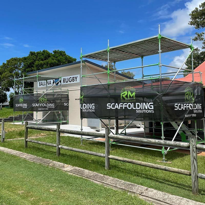 A Fence With Scaffolding in Front of a Building — RM Scaffolding Solutions in Lennox Head, NSW