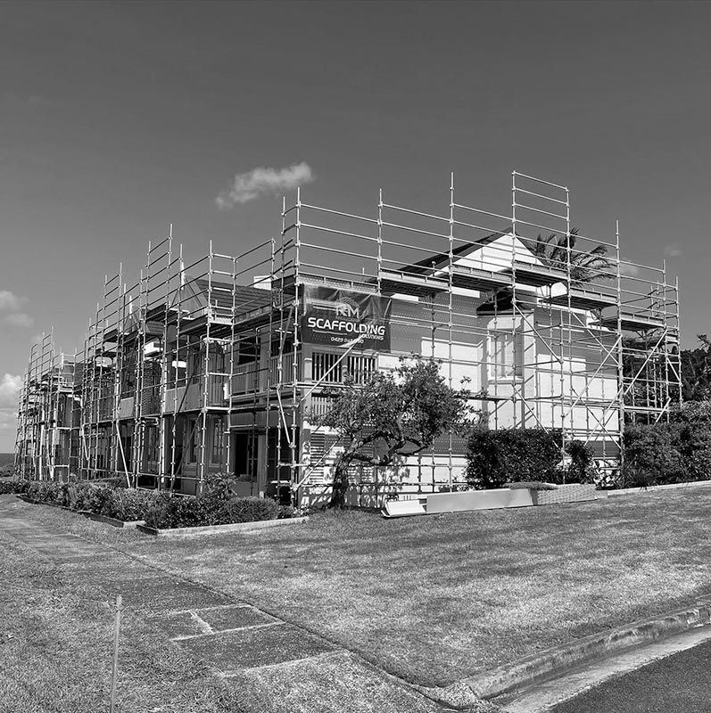 A Black and White Photo of a House Under Construction With Scaffolding Around It — RM Scaffolding Solutions in Yamba, NSW