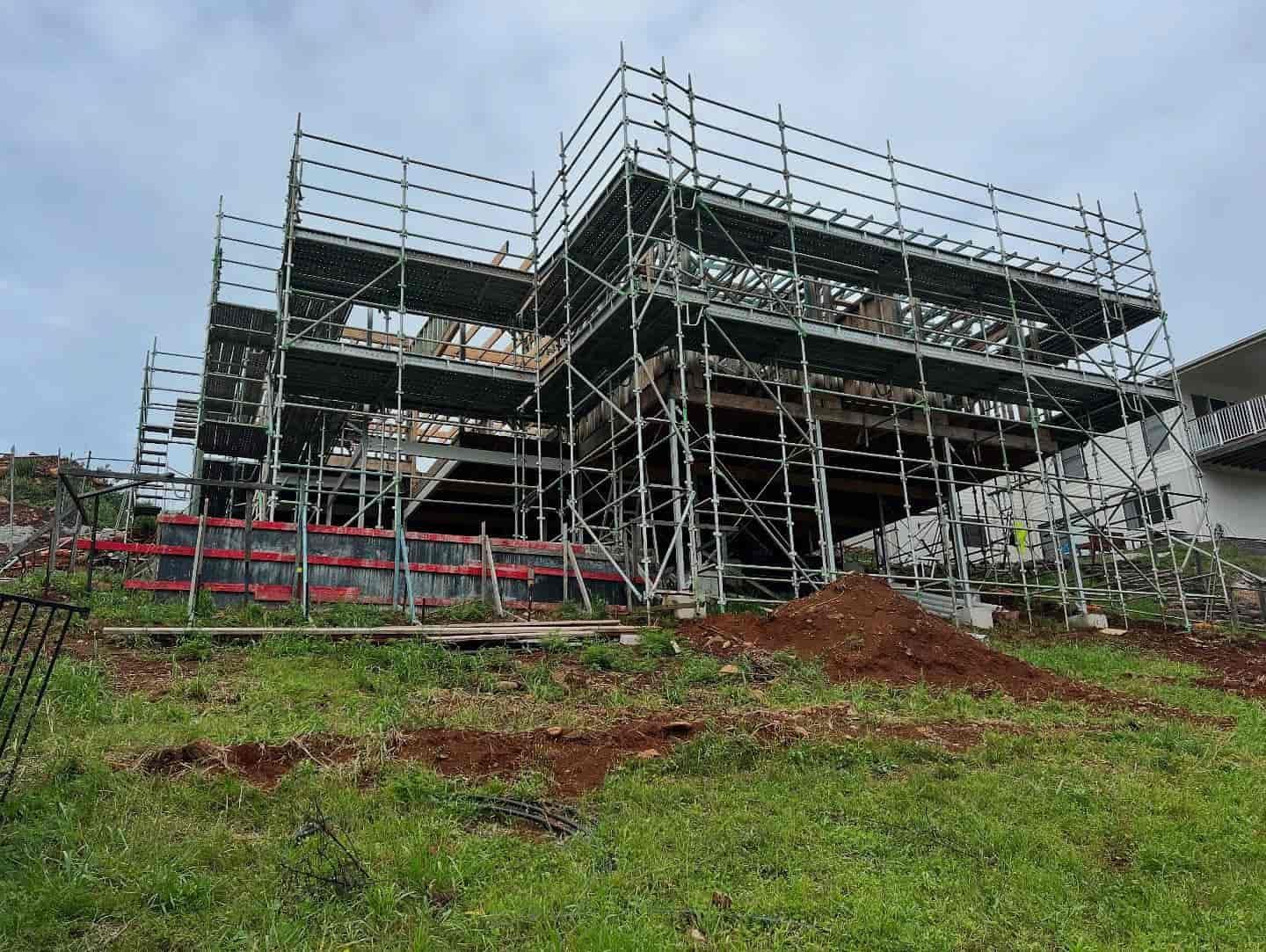 A Large House is Being Built on a Hill With Scaffolding Around It — RM Scaffolding Solutions in Tweed Heads, NSW