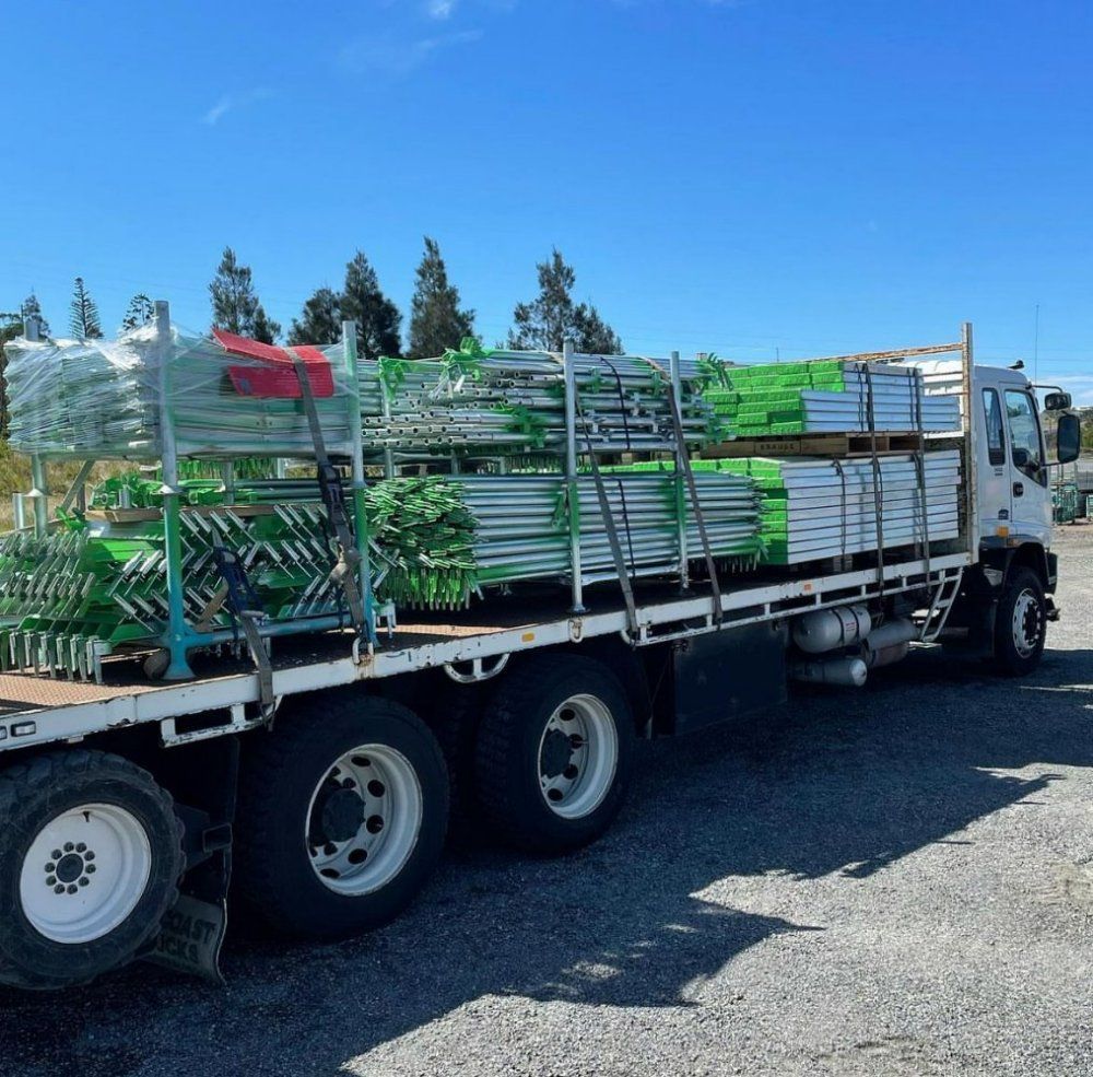 A White Truck is Loaded With Green Scaffolding — RM Scaffolding Solutions in Lismore, NSW