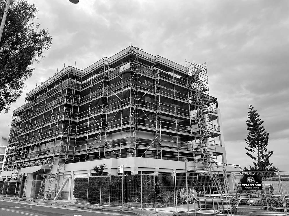 A Large Building is Being Built With Scaffolding Around It — RM Scaffolding Solutions in Lennox Head, NSW
