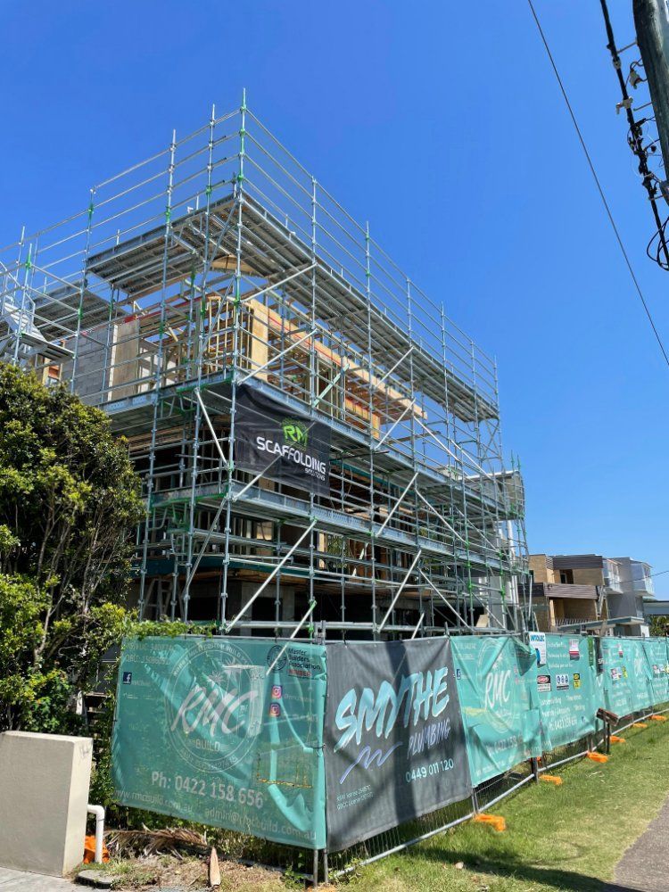A Building Under Construction With Scaffolding and a Fence Around It — RM Scaffolding Solutions in Lismore, NSW