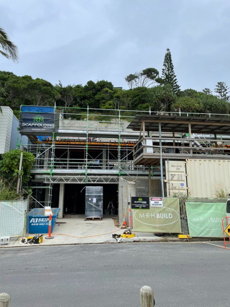 A Building Under Construction With Scaffolding and a Sign That Says High Build — RM Scaffolding Solutions in Lennox Head, NSW
