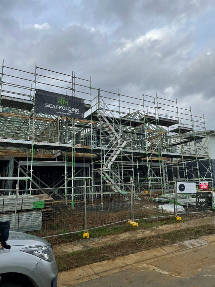 A Car is Parked in Front of a Building Under Construction — RM Scaffolding Solutions in Lennox Head, NSW
