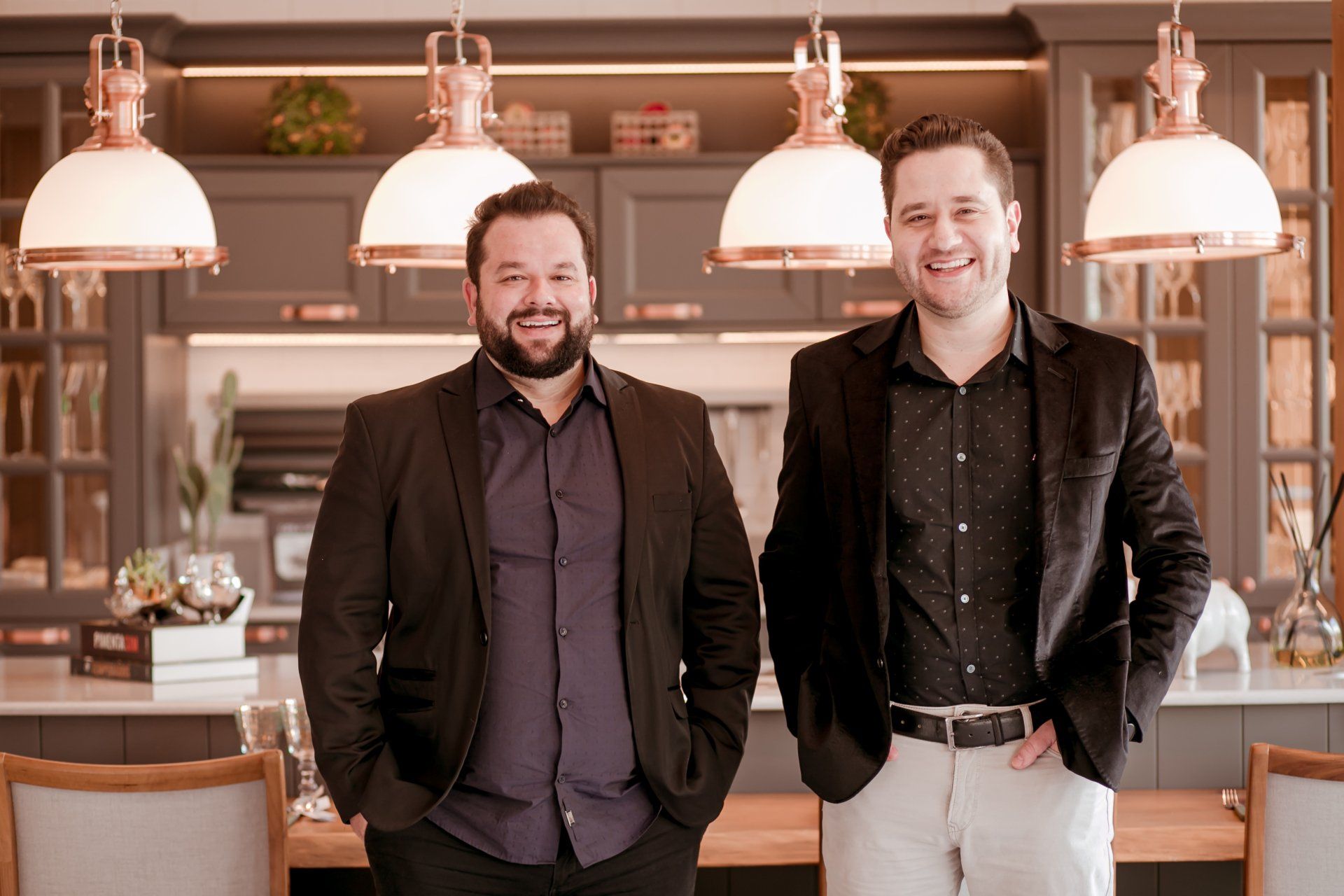 Dois homens estão um ao lado do outro em uma cozinha.