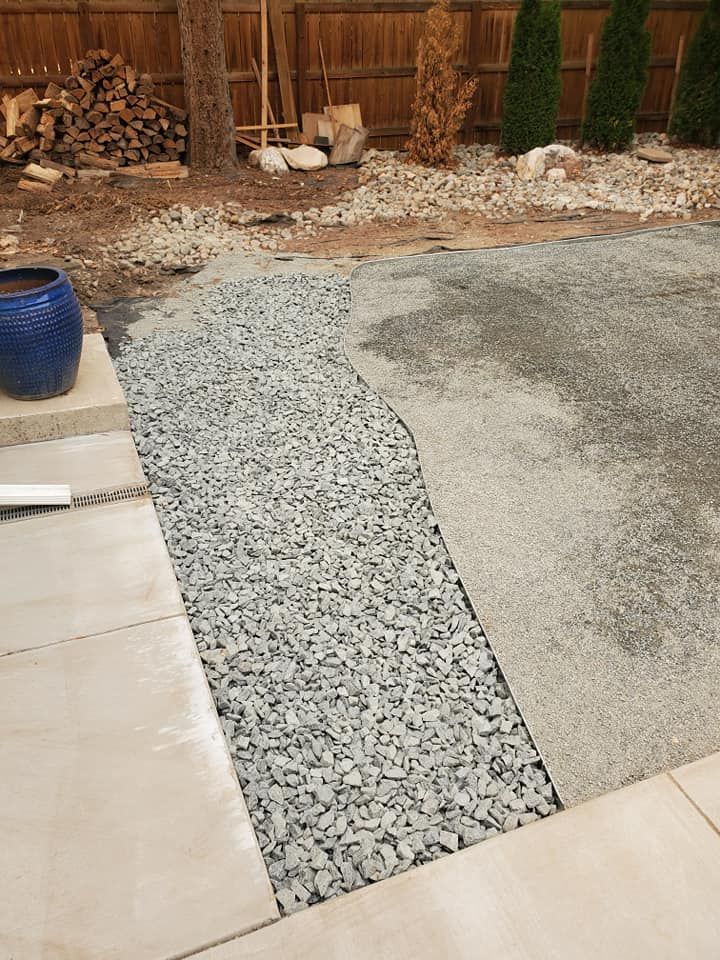 Patio construction with gravel path and stone pavers in a backyard setting.