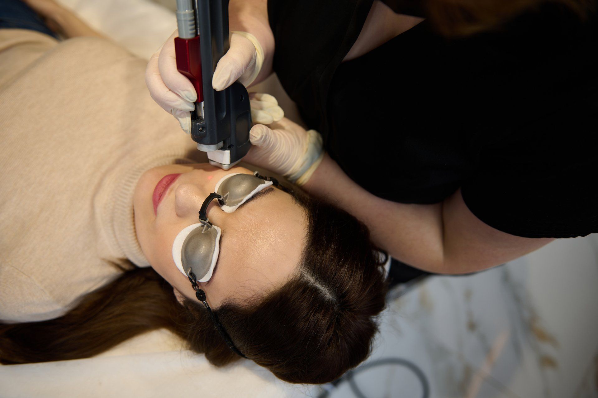 A woman is getting a laser treatment on her face.