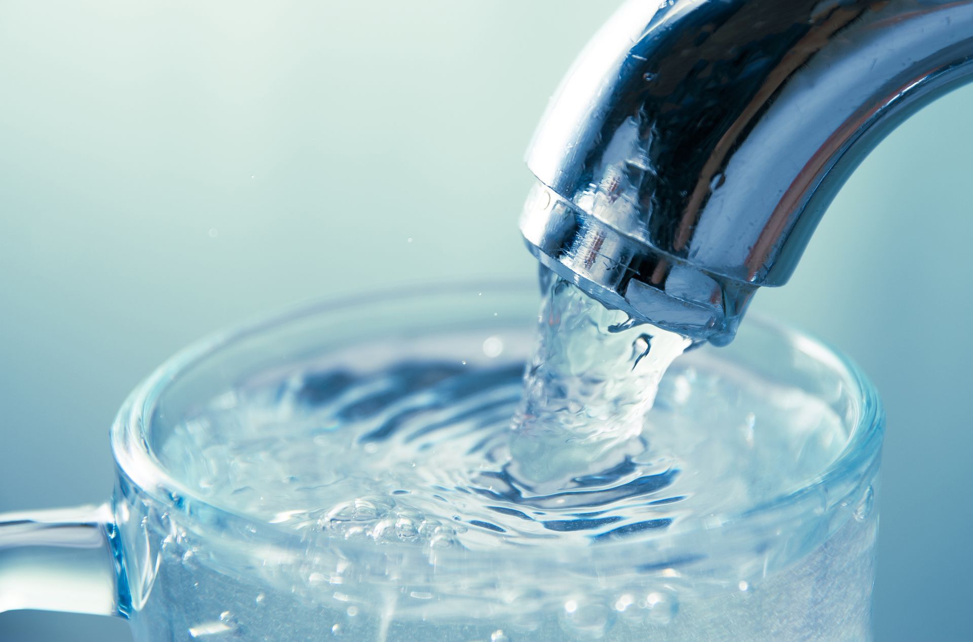 Modern kitchen sink with filtered water running from the tap, symbolizing clean water from in home.