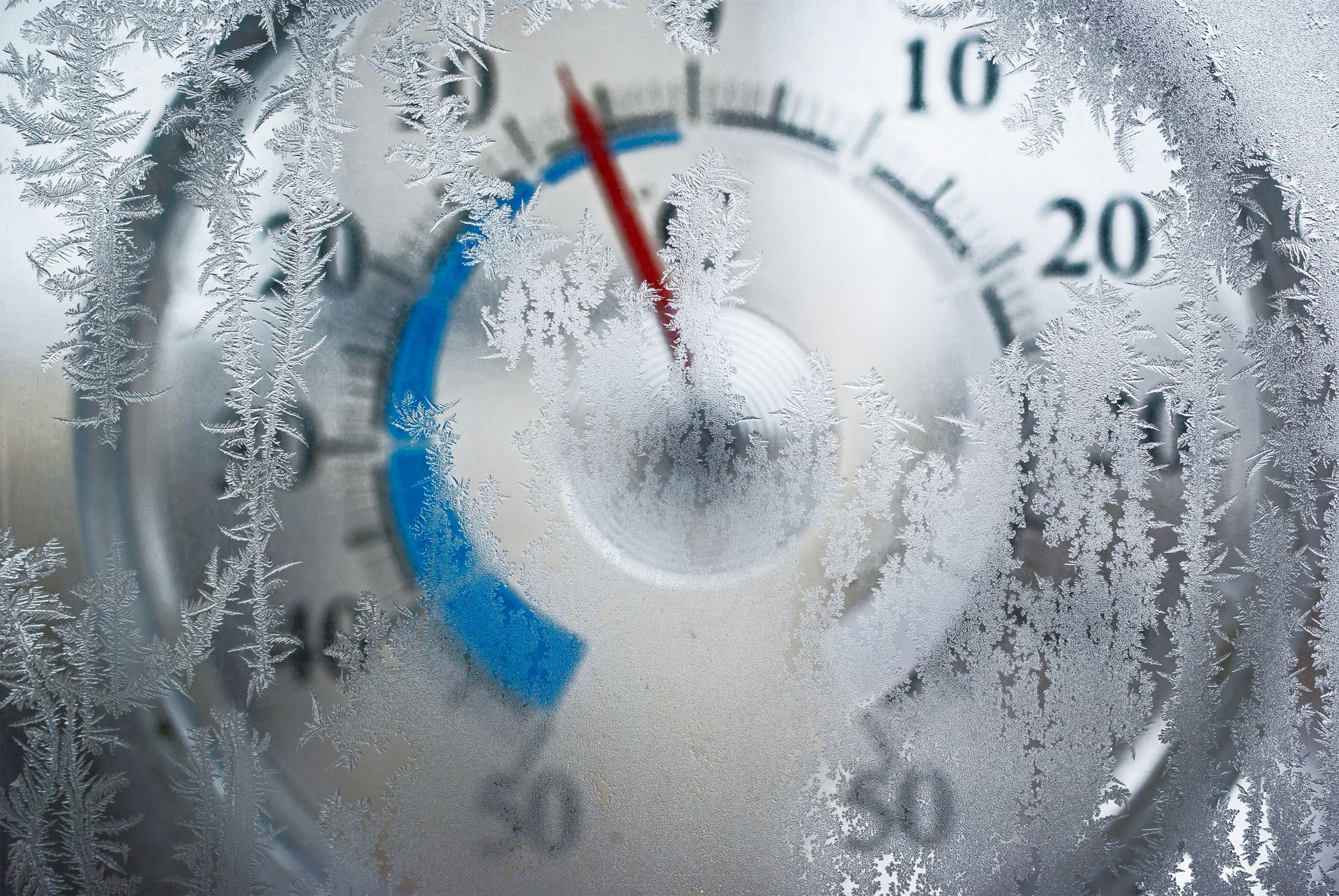 A close-up of a thermostat with ice crystals forming representing water softeners during freezing.