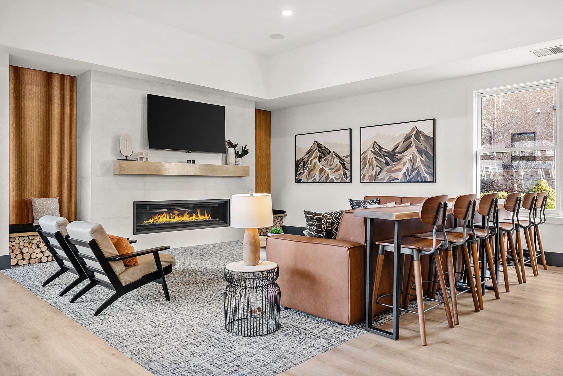 Modern apartment living room with a fireplace, wall-mounted TV, and bar-height dining counter.