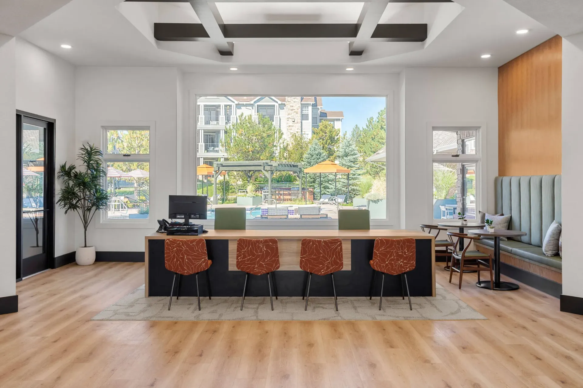Modern leasing office reception with a large window view of the outdoor pool area.
