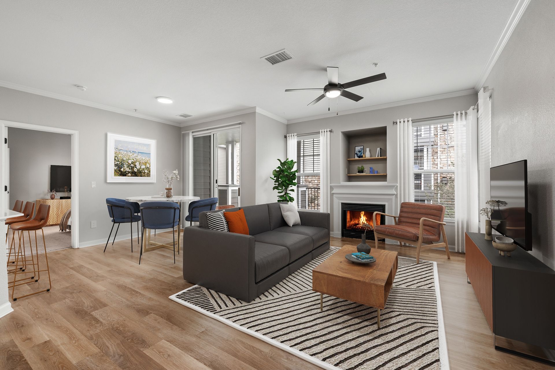 Bright living room in a modern apartment with a grey color palette, sofa, fireplace, and dining area.
