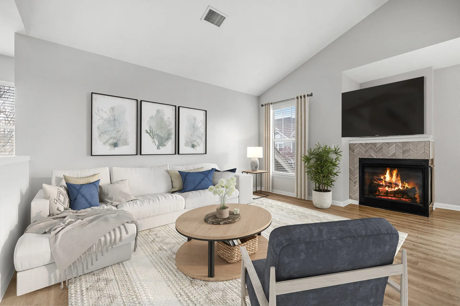 Bright living room with a white sectional sofa, fireplace, and large window.