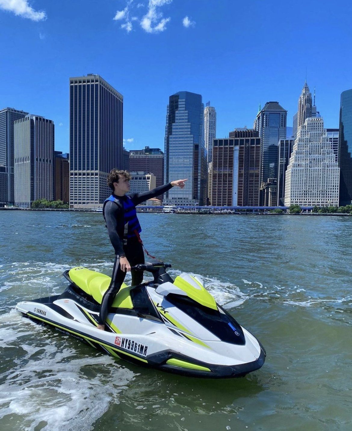man standing and pointing on yellow jet ski