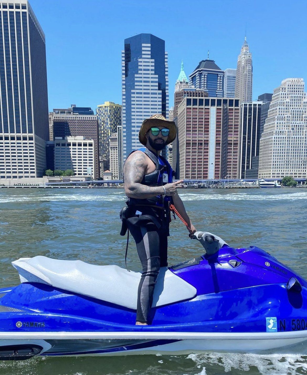 man standing on blue jet ski