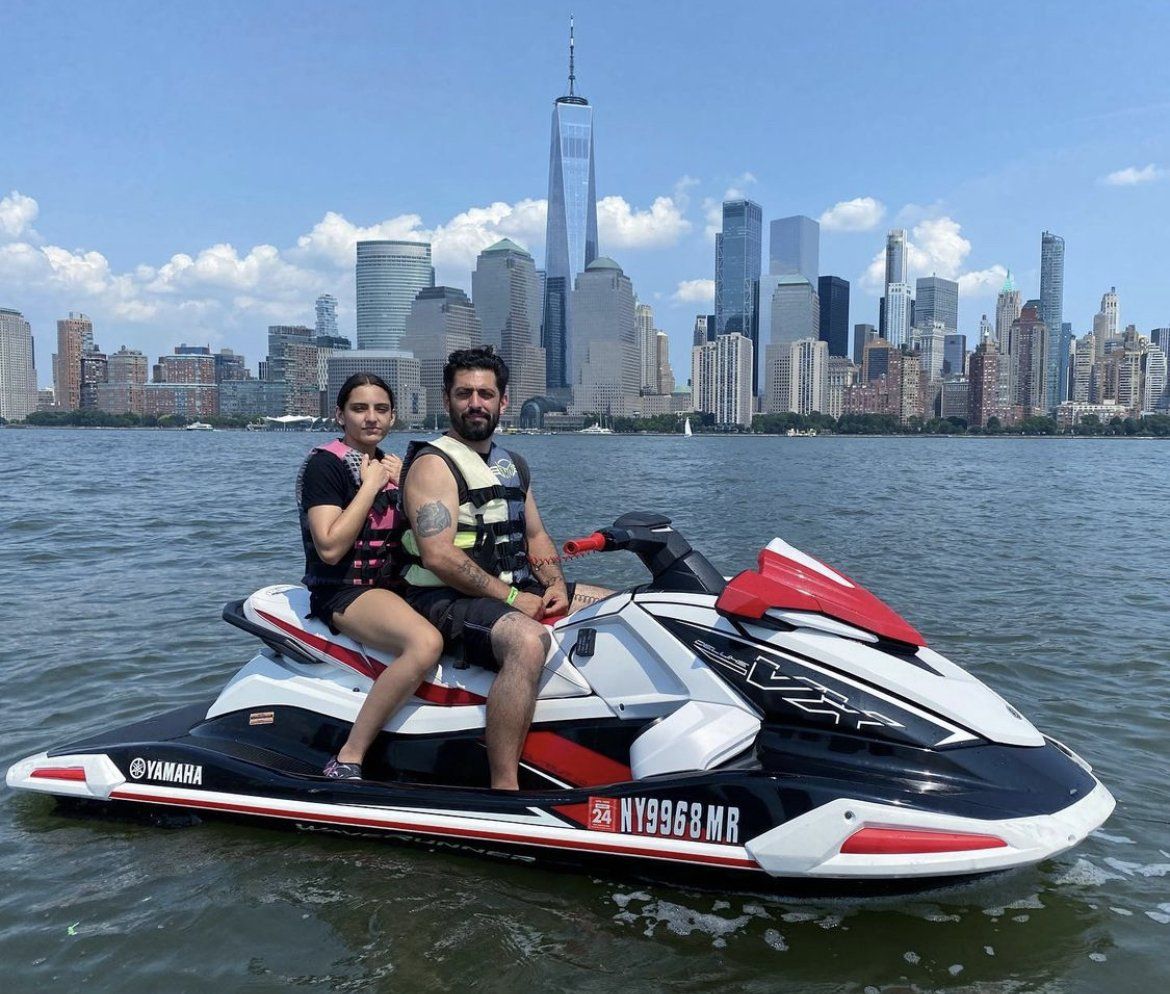 couple sitting on red jet ski