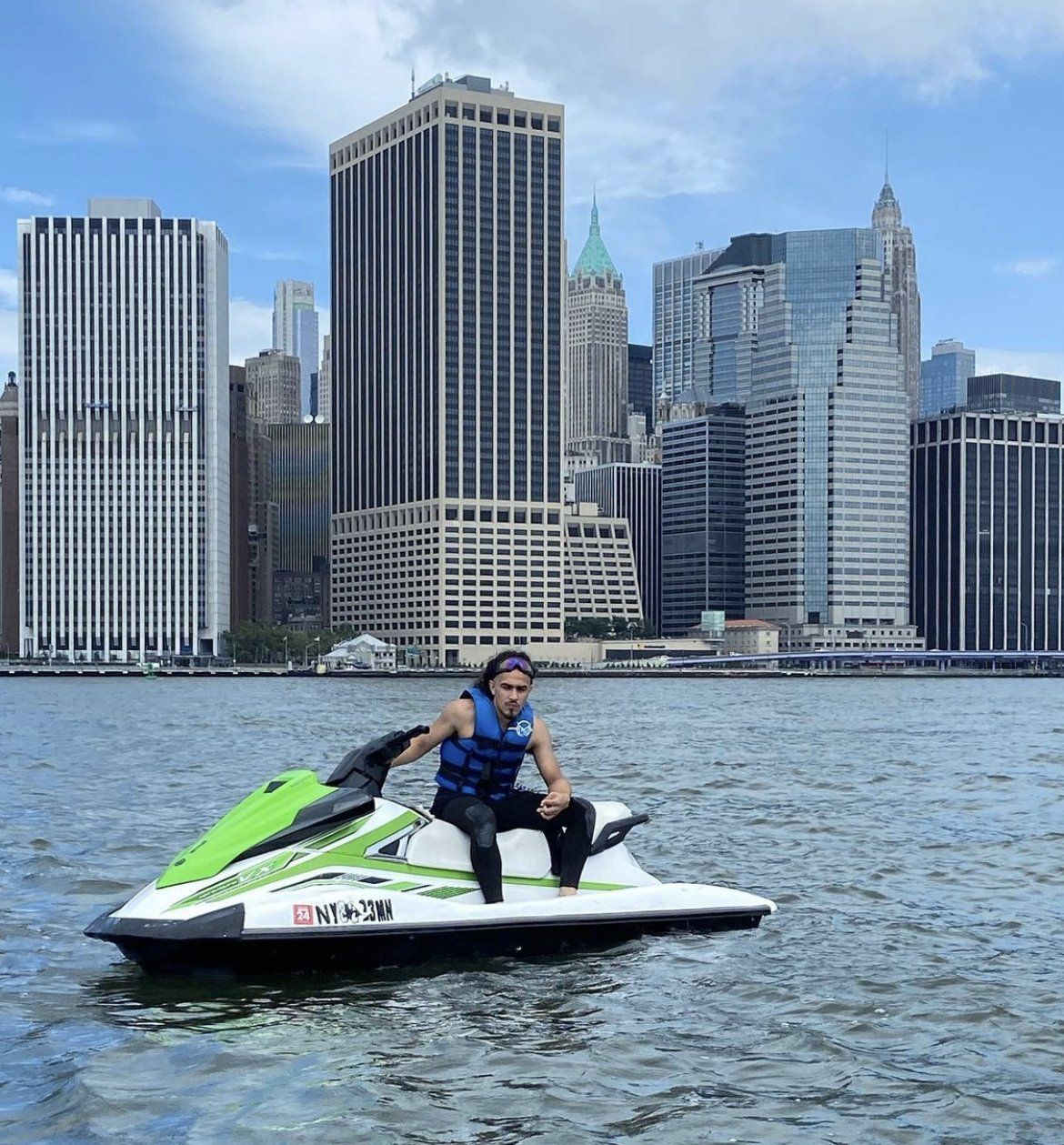 person sitting on green jet ski in water