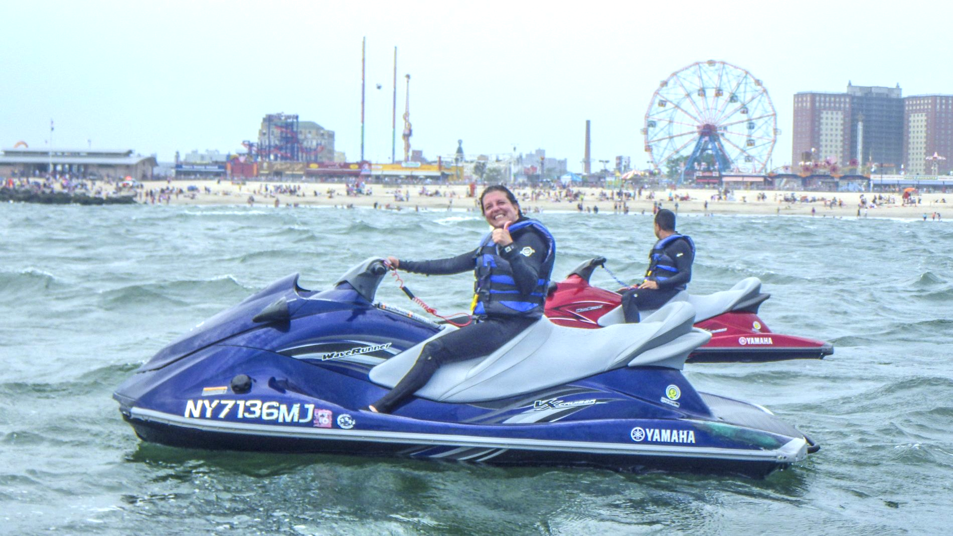girl giving thumbs up while riding on jet ski