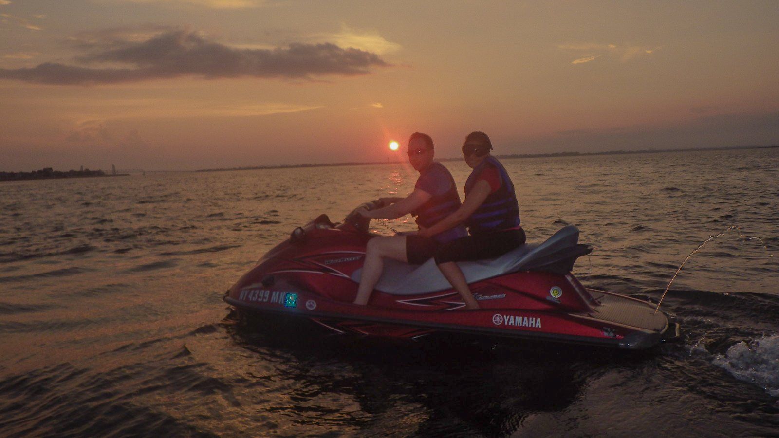 Happy couple riding jet ski