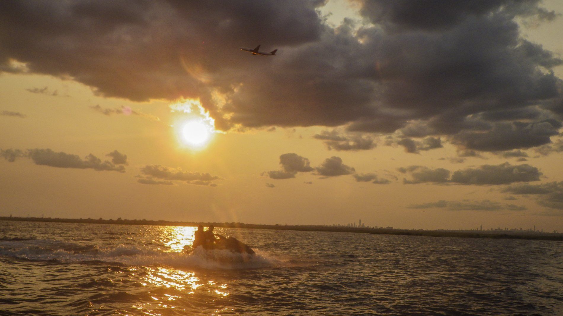 couple on jet ski with sun setting over ocean