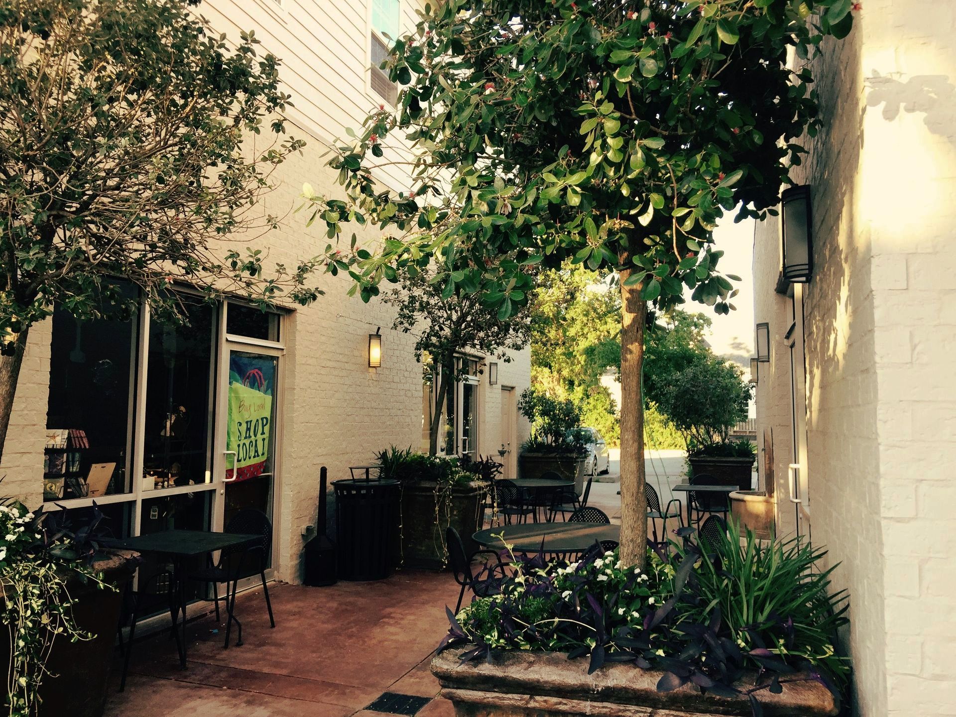 A patio with tables and chairs in front of a building with a sign that says ' patio ' on it