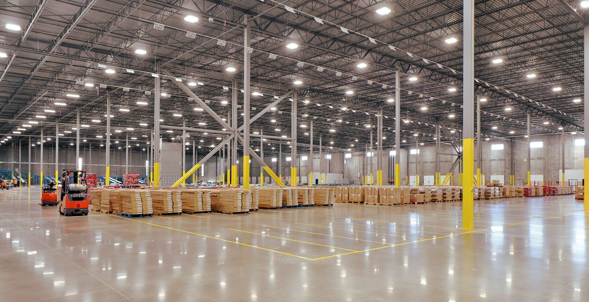 A large warehouse filled with lots of boxes and a forklift.