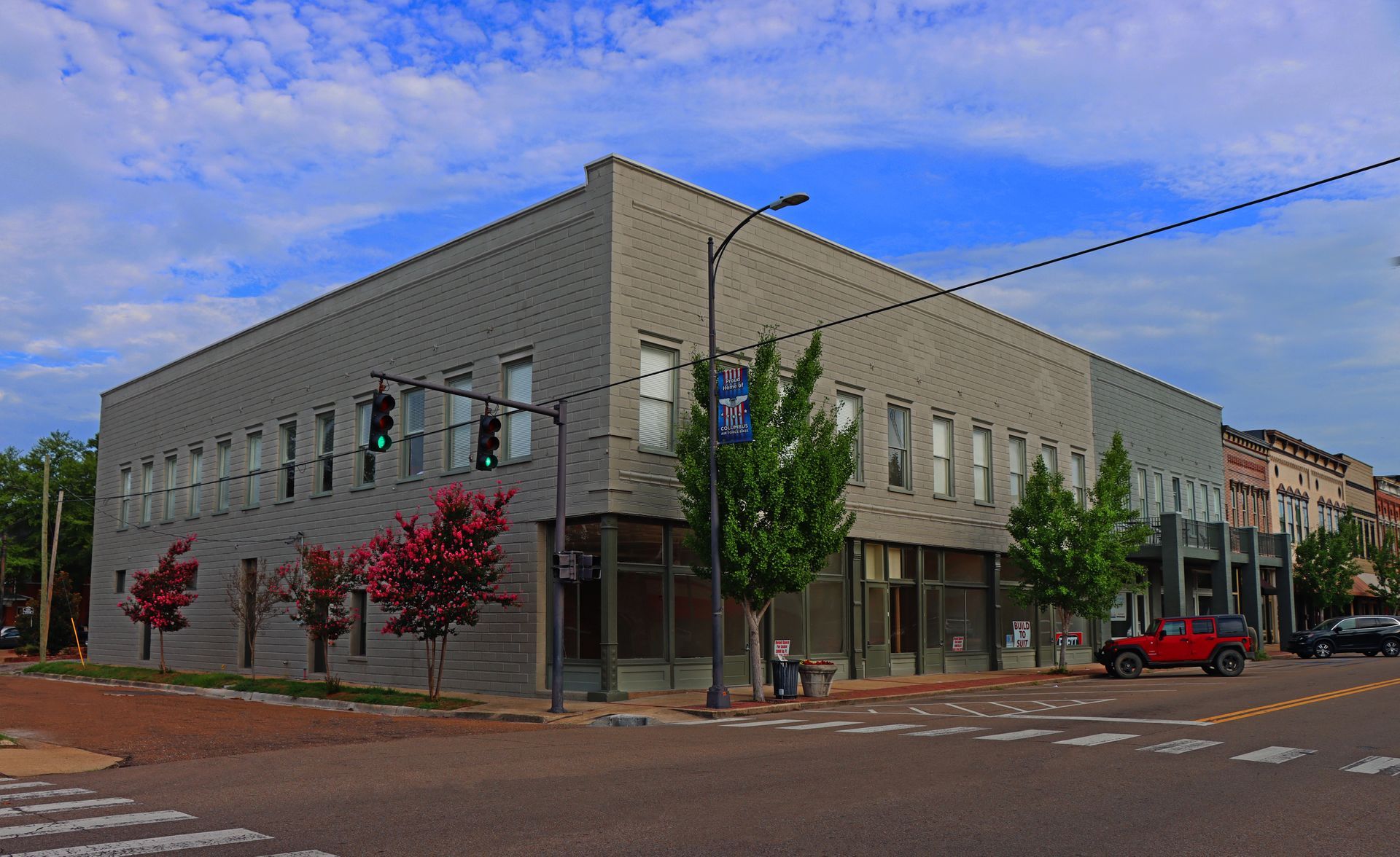 A large building is sitting on the corner of a city street.