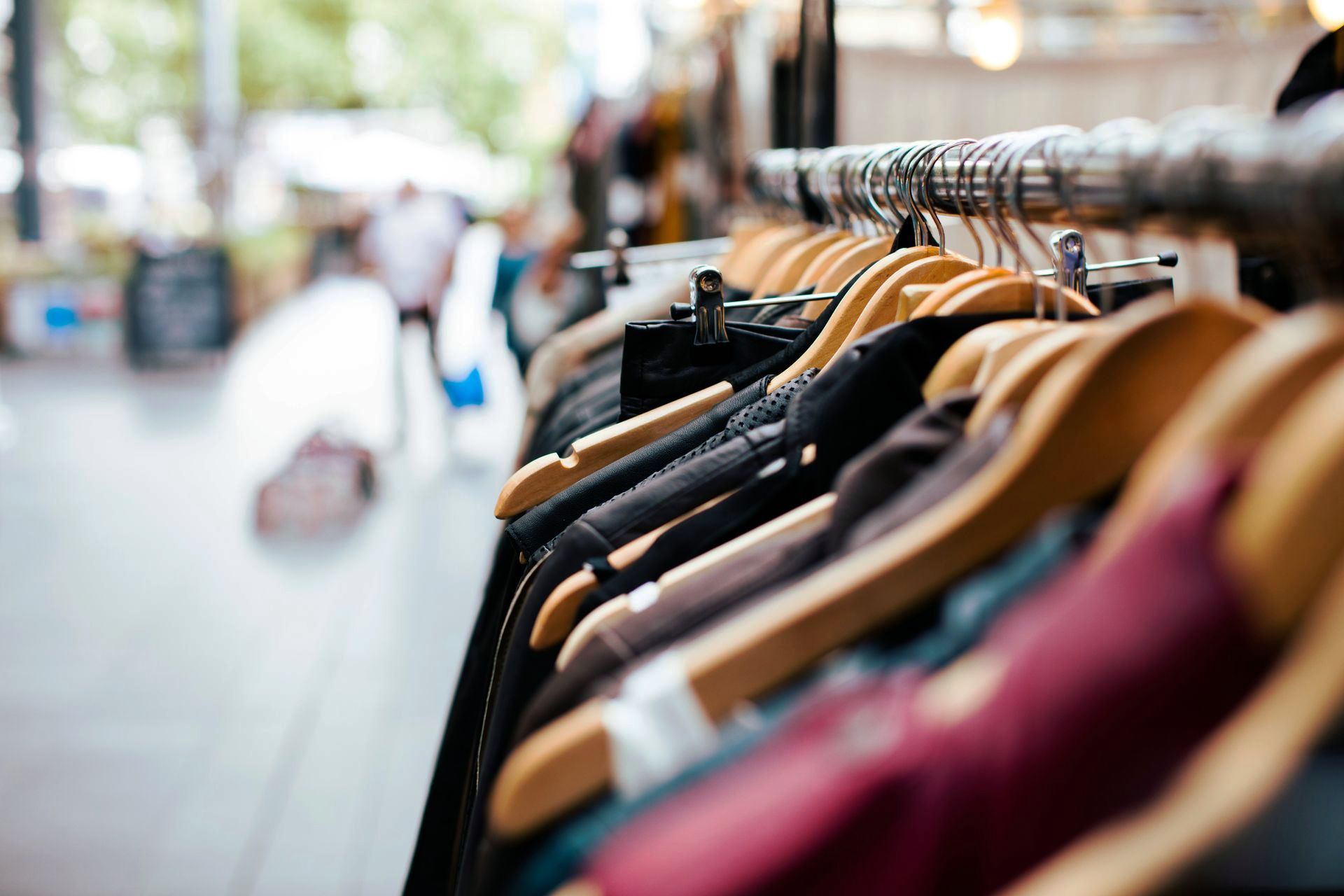 A row of clothes hanging on a rack in a store.