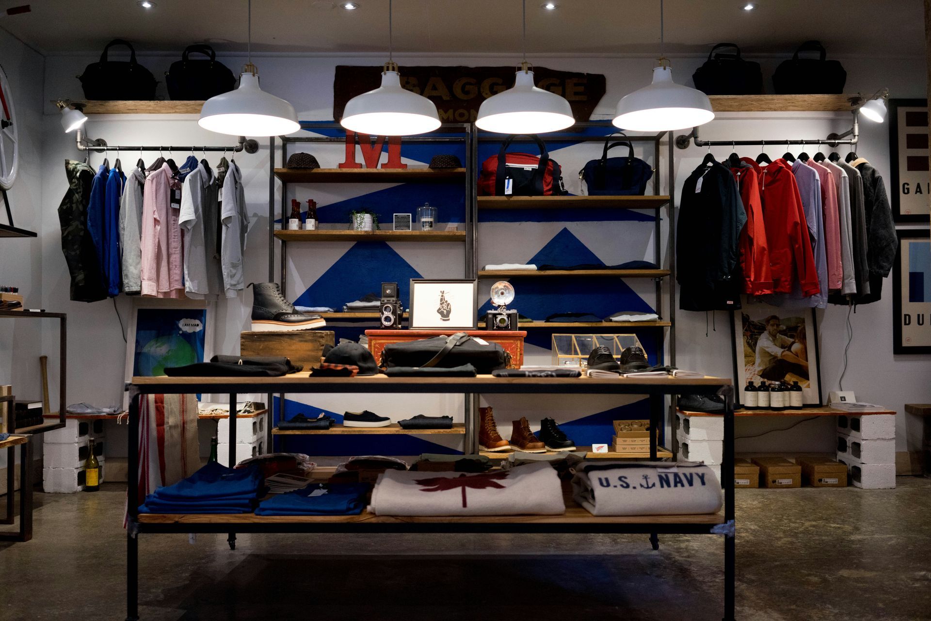 A clothing store with a table and shelves filled with clothes.