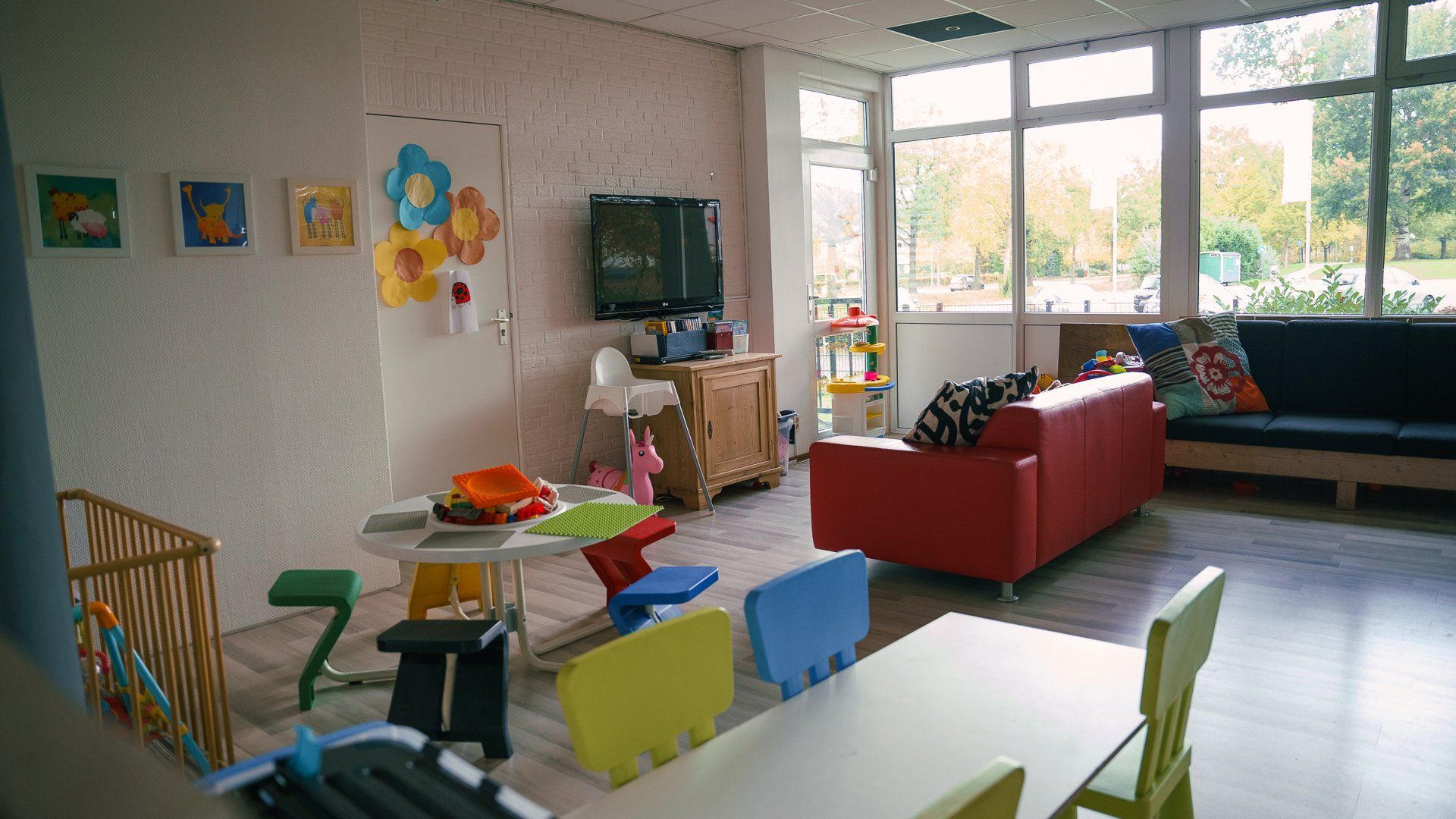 Een woonkamer met een tafel, stoelen, een bank en een televisie.