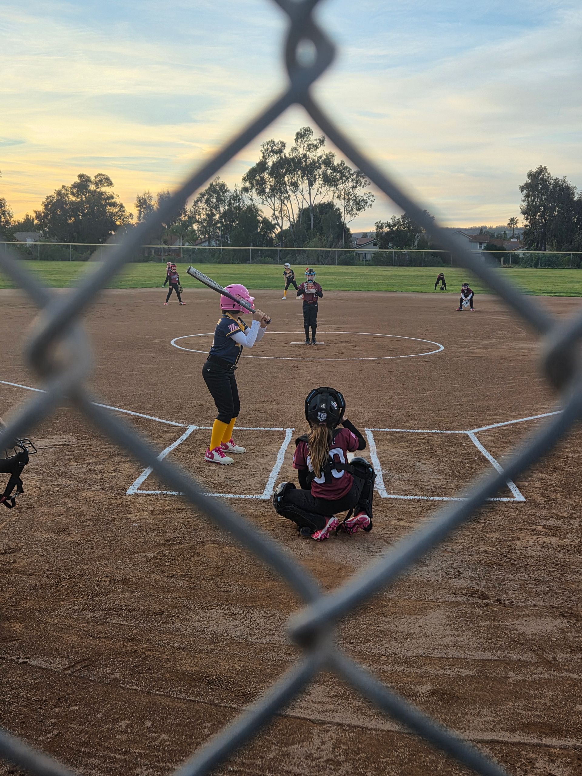 Baseball player sliding into base as another player attempts to catch the ball.