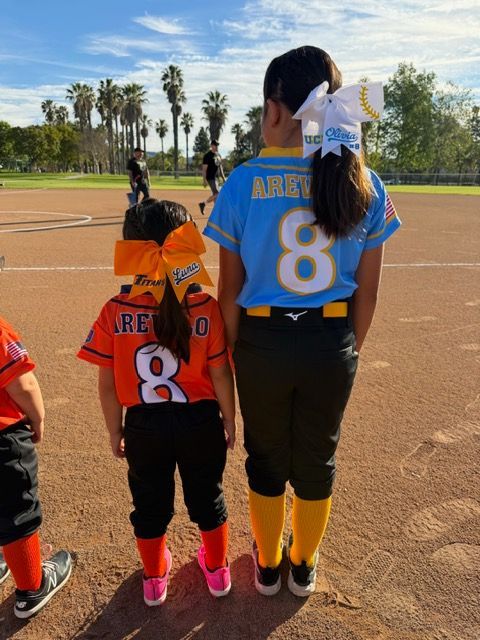 Baseball player sliding into base as another player attempts to catch the ball.