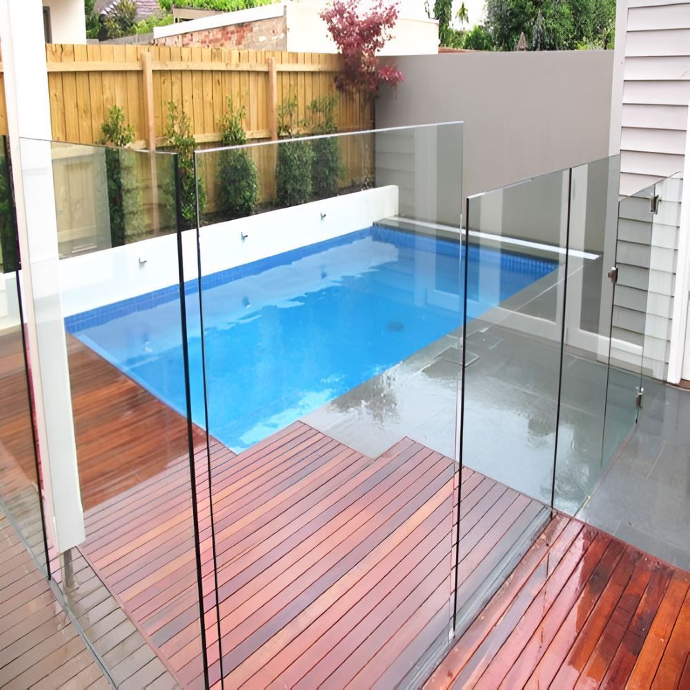 A Beautiful Swimming Pool With a Glass — Top Shelf Glass Pool Fencing & Balustrading in Merrimac, QLD