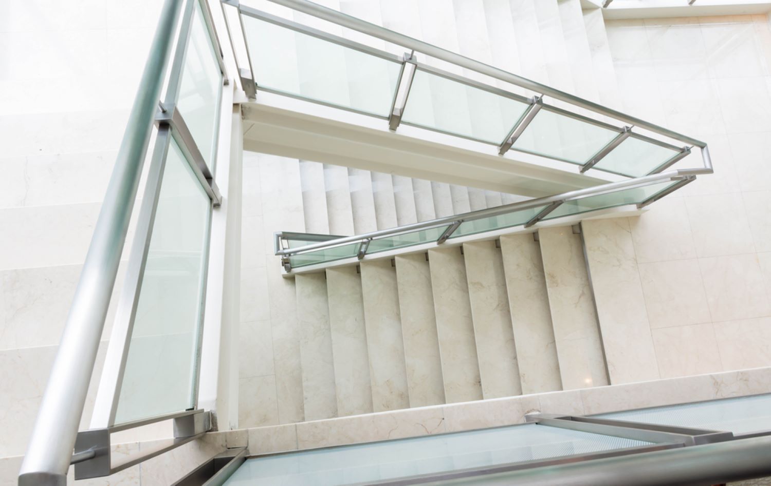 A Set of Stairs With a Glass Railing in a Building — Top Shelf Glass Pool Fencing & Balustrading in Beenleigh, QLD