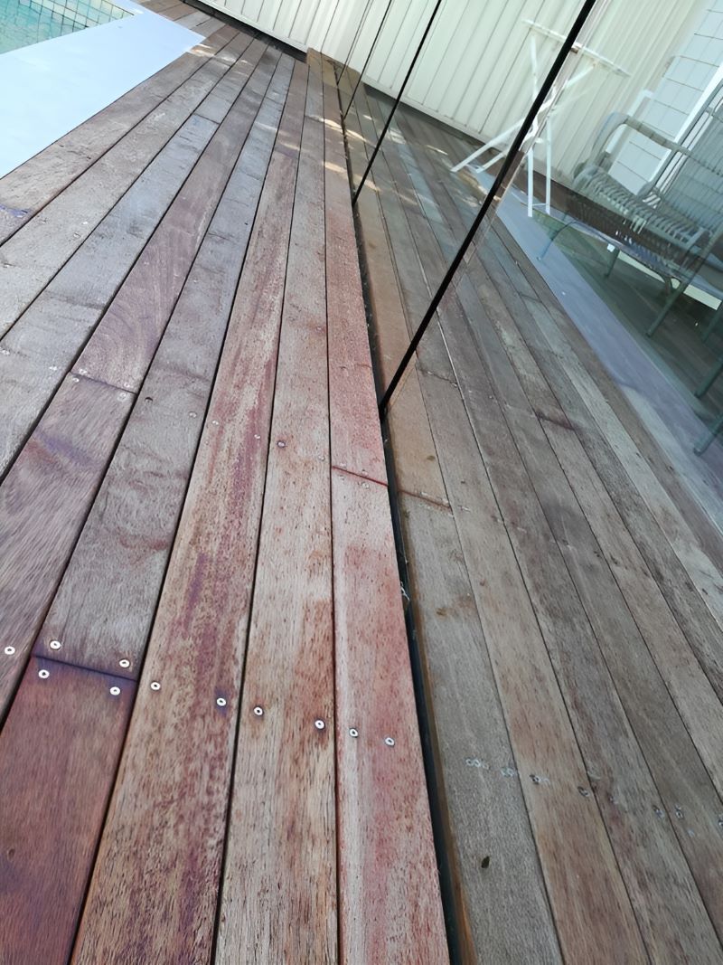 A Wooden Deck With a Glass Fence Around It — Top Shelf Glass Pool Fencing & Balustrading in Brisbane, QLD