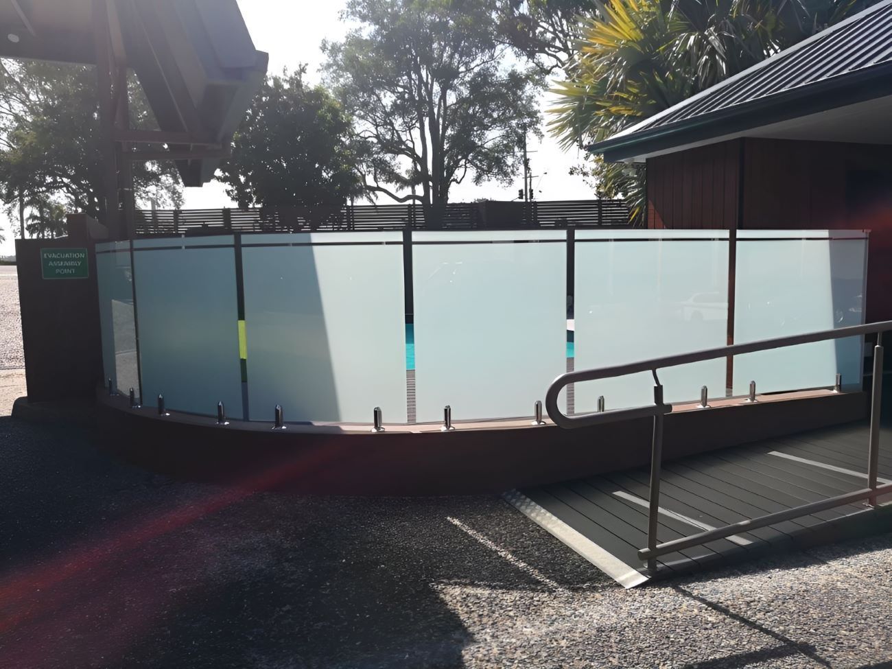 A Glass Fence With a Ramp in Front of It — Top Shelf Glass Pool Fencing & Balustrading in Helensvale, QLD