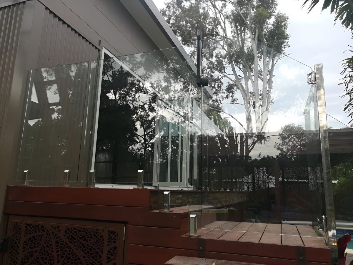 A House With a Glass Railing on the Side of It — Top Shelf Glass Pool Fencing & Balustrading in Helensvale, QLD
