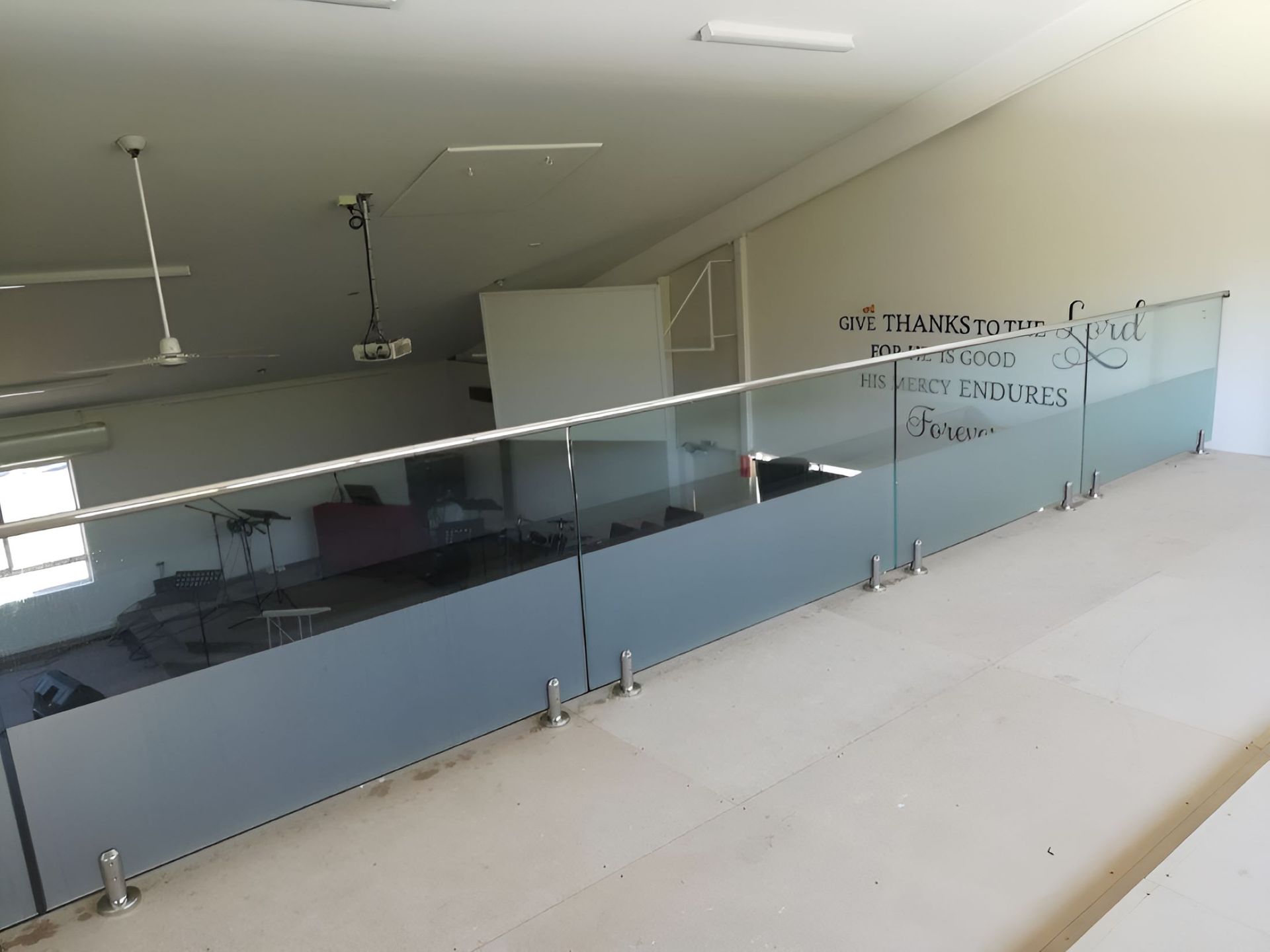 A Balcony With a Stainless Steel Railing and a Quote on the Wall — Top Shelf Glass Pool Fencing & Balustrading in Beenleigh, QLD