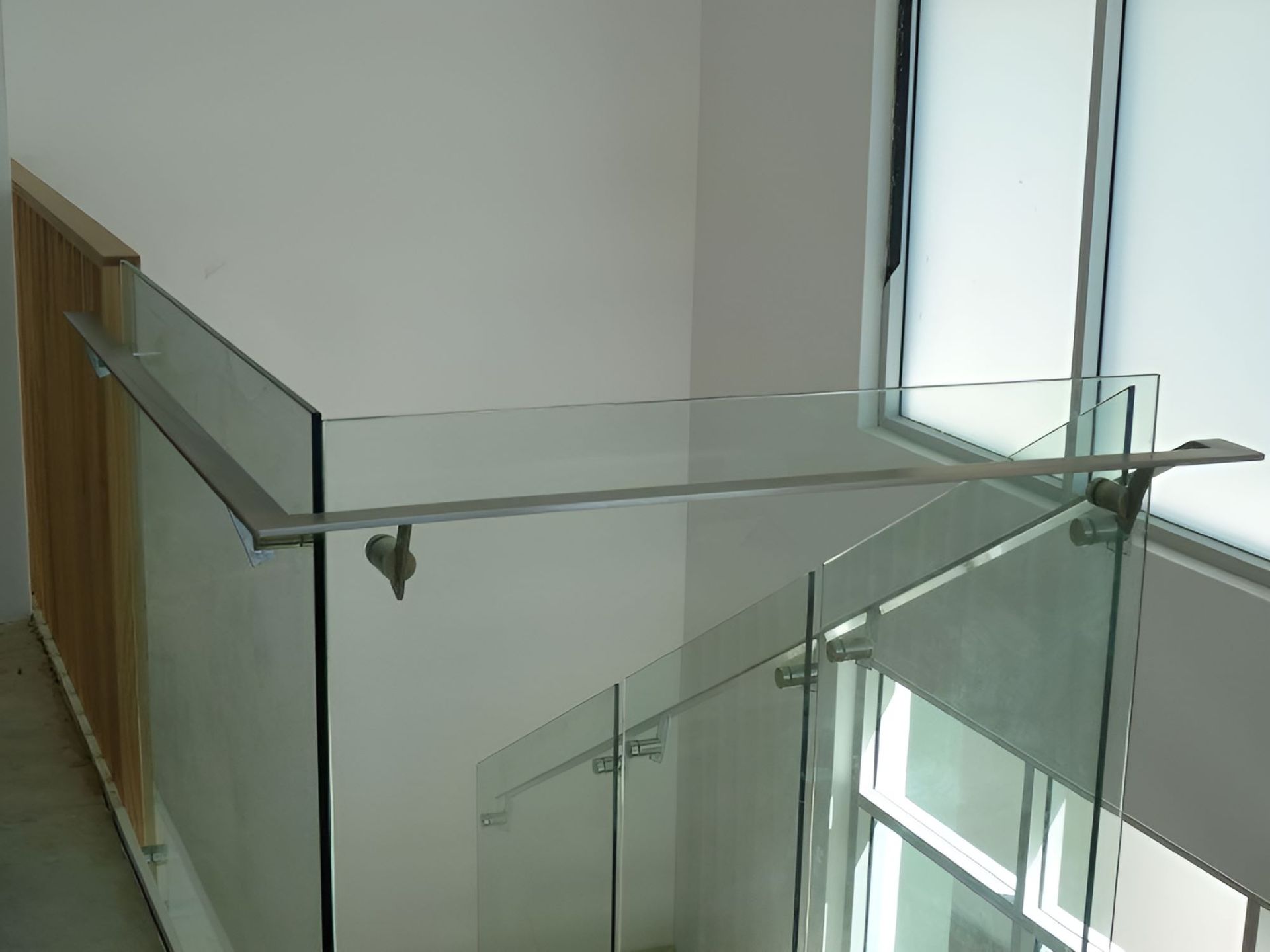 A Staircase With a Glass Railing and a Window — Top Shelf Glass Pool Fencing & Balustrading in Merrimac, QLD
