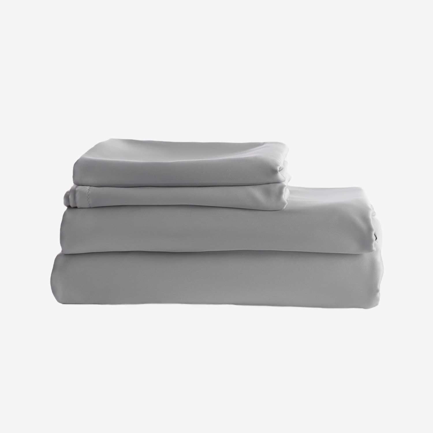 Four folded gray bed sheets stacked on a white surface.