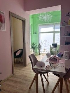 Una stanza con un tavolo, delle sedie e una parete verde.